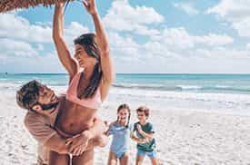 Famiglia con ragazzo e ragazza felici sulla spiaggia