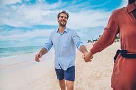 Couple heureux marchant sur la plage